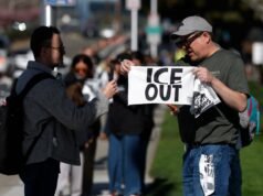 Gli attivisti distribuiscono gli asciugamani “ICE OUT” al Super Bowl LX