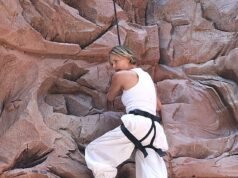 Charlize Theron supera la paura dell’altezza scalando la parete da arrampicata inserita in un gigantesco cartellone pubblicitario a Times Square per promuovere il nuovo film