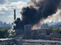 Circa 100 vigili del fuoco combattono un enorme incendio in un centro di riciclaggio mentre spessi pennacchi di fumo si sollevano attraverso lo skyline di Londra