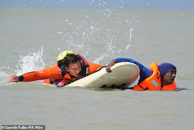 109367275-15901879-Rescuers_used_a_surf_board_to_reach_migrants_attempting_to_board-a-2_1781546903395.jpg