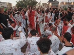 I musulmani rimangono inzuppati di sangue mentre si tagliano con i coltelli per celebrare la festa islamica