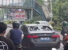 BMW elettrica investita dalla folla dopo essersi schiantata contro una moto a Giacarta ovest, la polizia assicura che il caso si concluda pacificamente