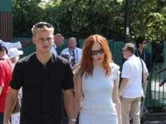 Ellie Bamber scambia l’eleganza di Wimbledon con un top con stampa floreale e una sciarpa del West Ham mentre filma una delle storie più folli di sempre del calcio