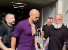 Lo sfacciato Andrew Tate sembra provare a passare il telefono alla guardia del corpo mentre viene arrestato con l’accusa di pornografia infantile