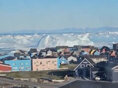 Un enorme iceberg si capovolge provocando onde simili a tsunami al largo della città costiera della Groenlandia