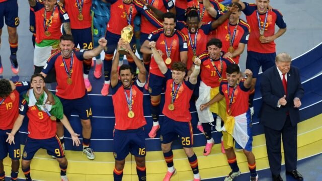 6a5dec61c6a77-momen-trump-ogah-turun-dari-podium-saat-timnas-spanyol-rayakan-kemenangan-piala-dunia-2026_gemini_1265_711.jpg