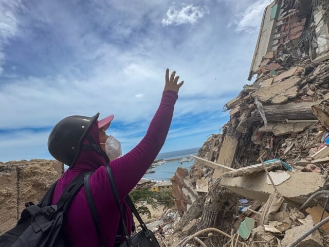 Andreina-Velasquez-points-to-one-of-the-higher-floors-where-her-apartment-was-in-Catia-la-Mar-1782926272.jpeg