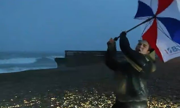 Il giornalista televisivo con l’ombrello in mano viene quasi spazzato via dalla tempesta Austen mentre i presentatori vengono colpiti da venti a 80 miglia all’ora Il giornalista televisivo con l’ombrello in mano viene quasi spazzato via dalla tempesta Austen mentre i presentatori vengono colpiti da venti a 80 miglia all’ora